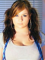 Busty Teen Tara poses in her kitchen wearing a tartan skirt and bra